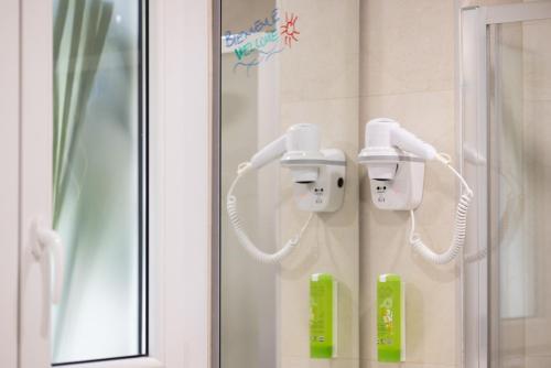 un bagno con due telefoni sul muro di Hôtel Locarno Nice a Nizza