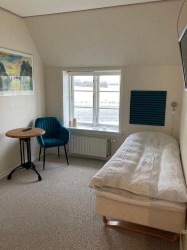 a bedroom with a bed and a table and a chair at Lykkebjerg in Varde