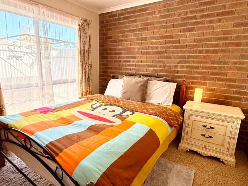 a bedroom with a bed with a mickey mouse blanket at Unit 4 - Stawell, Golden Patch Retreat in Stawell