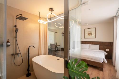 a bathroom with a bath tub and a bedroom at Saigon Maison 1988 BUI VIEN Centre in Ho Chi Minh City