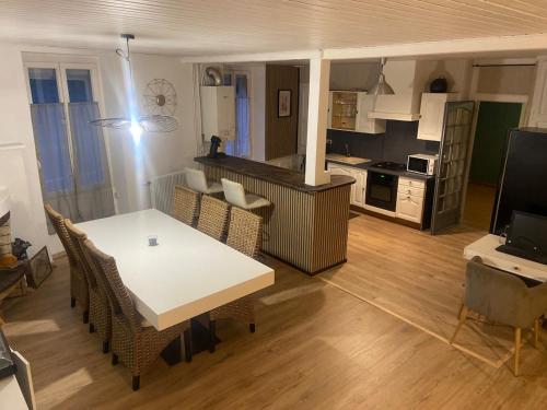 a living room with a table and chairs and a kitchen at Le Loft Dolois, Maison Loft in Dole