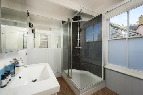 a bathroom with a glass shower and a sink at Walters on The Digey - 100m to beach - pets allowed in St Ives