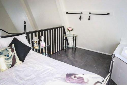a bedroom with a white bed with a black headboard at GREEN TREES CHALET Australia Zoo close by in Landsborough