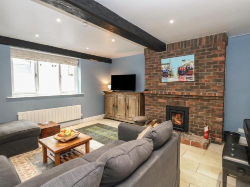 a living room with a couch and a fireplace at The Grain Store in Weymouth