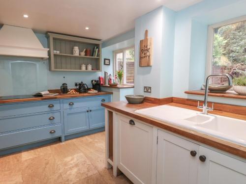 a kitchen with blue and white cabinets and a sink at The Grain Store in Weymouth