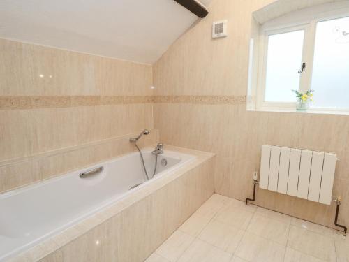 a bathroom with a bath tub and a window at The Grain Store in Weymouth