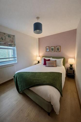 a bedroom with a large bed and two lamps at The Inver Nest in Inverness