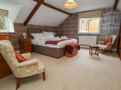 a bedroom with a bed and chairs in a room at The Grain Store in Weymouth