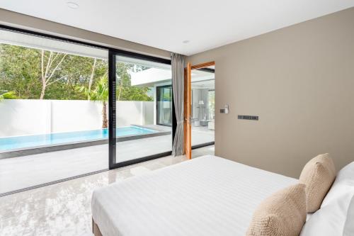 a bedroom with a bed and a view of a pool at Dapple Villa in Na Mueang