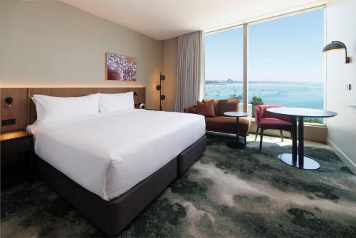 a hotel room with a large bed and a large window at Crowne Plaza Geelong by IHG in Geelong