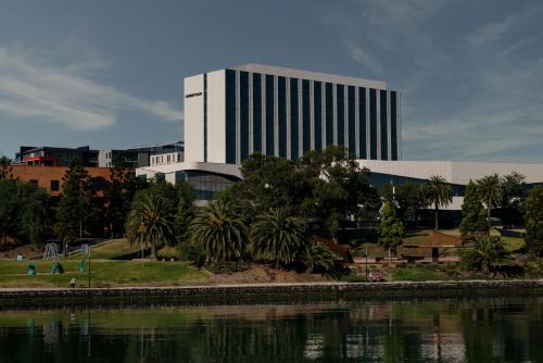 a tall building next to a body of water at Crowne Plaza Geelong by IHG in Geelong