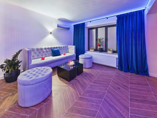 a living room with a purple couch and blue curtains at Jacuzzi LoveAparts Marki Romantic Getaway in Marki