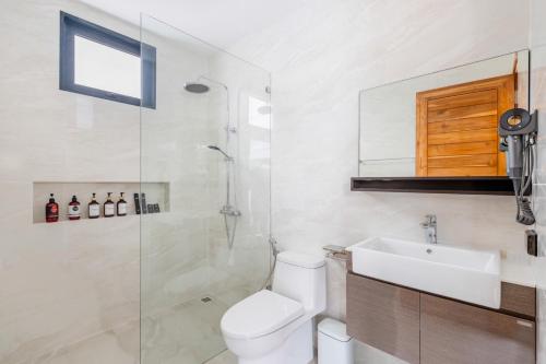 a bathroom with a toilet and a sink and a shower at Dapple Villa in Na Mueang