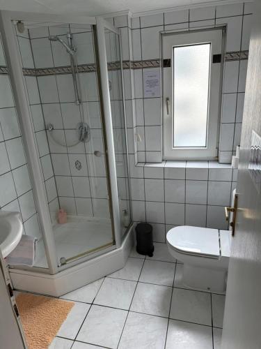 a bathroom with a shower and a toilet and a sink at Pension Hoffmann Remscheid in Remscheid