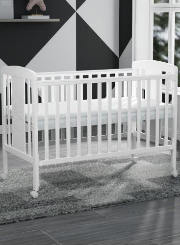 a white crib sitting in a room with a rug at Intermass building in Sharjah