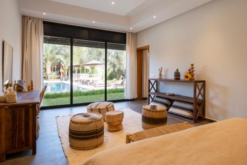 a living room with a table and some chairs at Bab Akoul Palmeraie - Boutique Hotel & Spa in Marrakesh