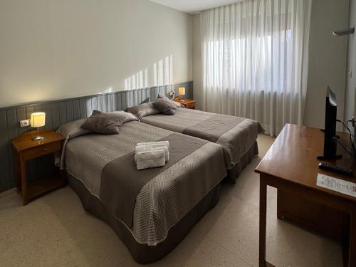 a bedroom with a large bed and a desk at Hotel Isabel de Segura in Teruel