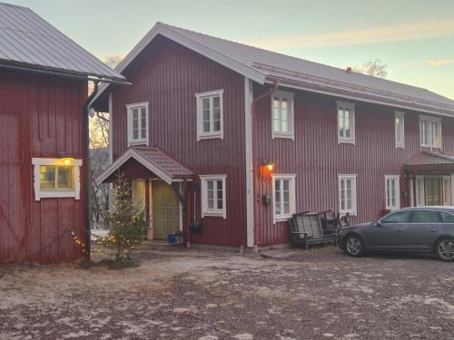 una casa roja con un coche aparcado delante en Backamgården, en Sälen
