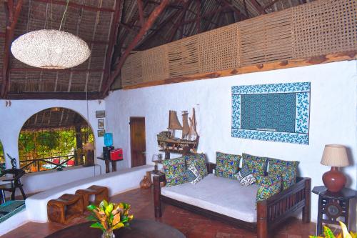 a living room with a couch and a table at Sansuri Dreams Beach House in Msambweni