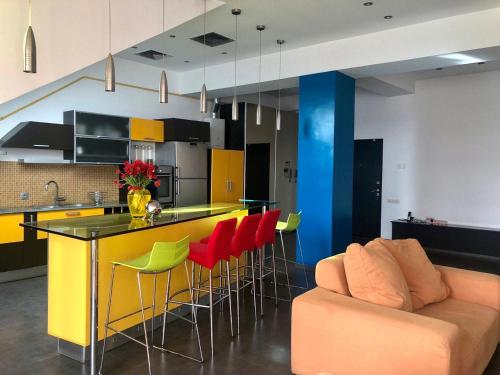 エレバンにあるYerevan Loftのカラフルな椅子とソファのあるバーのあるキッチン
