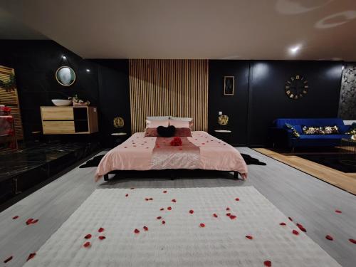 a bedroom with a bed with red rose petals on the floor at Saphir in Plouray