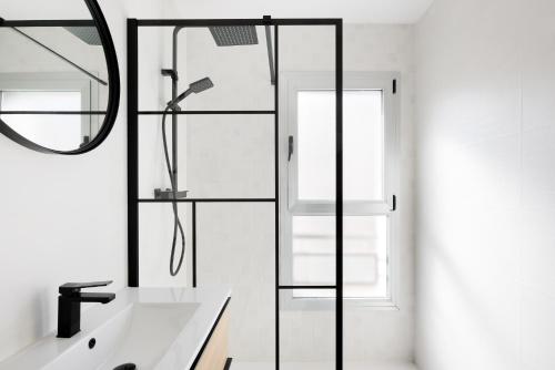 a bathroom with a shower with a sink and a mirror at MÁ HOMES Postigos in Málaga