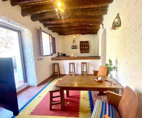 a living room with a wooden table and a kitchen at Casa Amigos Sorvilan - la Bodega in Sorvilán