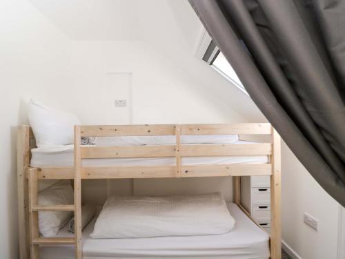 a bunk bed in a room with a window at Barn Cottage with pre booked use of Indoor Swimming Pool in Frome