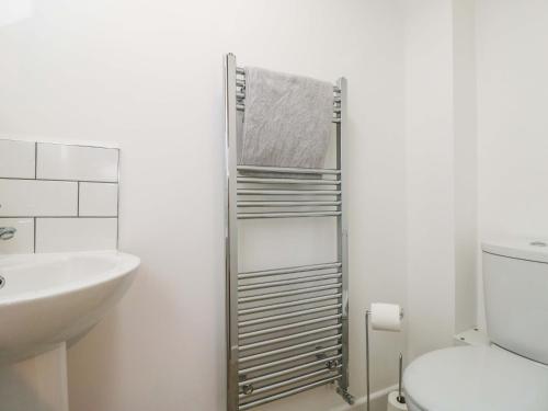 a bathroom with a towel rack next to a toilet at Barn Cottage with pre booked use of Indoor Swimming Pool in Frome