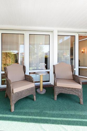 two chairs and a table on a porch at Ferienhaus Blauer Anker in Bensersiel