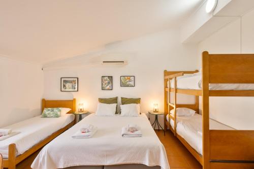 two beds in a room with two bunk beds at ABLA Guest House in Carcavelos