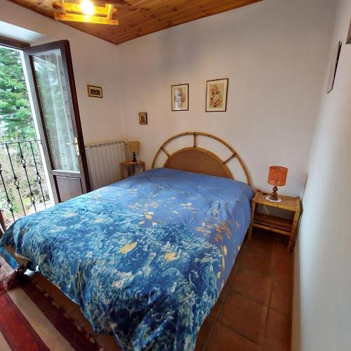 a bedroom with a bed with a blue comforter at Il Paradiso Della Montagna in Cutigliano