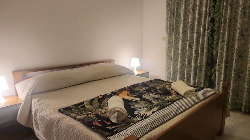 a bed with a blanket on it with two pillows at Serenity Naxos Vacation Home in Giardini Naxos