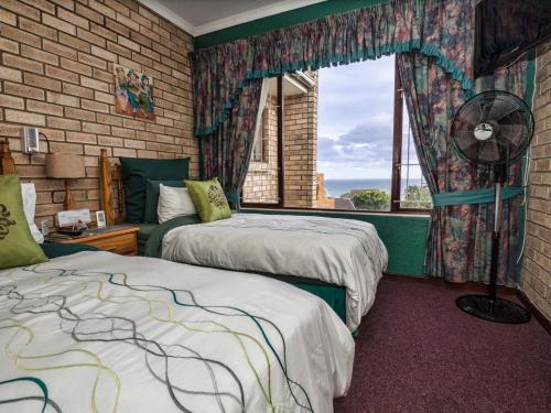 ポート・アルフレッドにあるVilla Majestic for Exclusive Accommodationの窓、ファンが備わるドミトリールームのベッド2台分です。