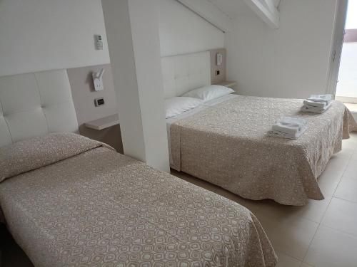 two beds in a white room with two beds sidx sidx sidx at Hotel Riviera in Silvi Marina