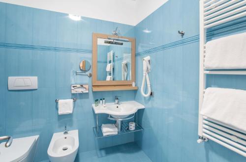 a blue bathroom with a sink and a toilet at Marc Hotel in Vieste