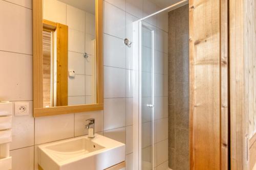 a bathroom with a sink and a mirror at Dormio Resort Les Portes du Grand Massif in Flaine