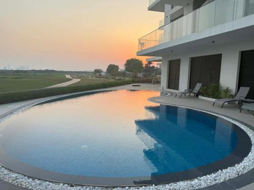 a swimming pool in front of a building at Golf view living by FlamingoAmber Dubai in Ajman