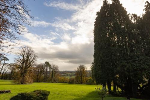 a group of trees in a green field at The Coed-Y-Mwstwr Hotel in Bridgend