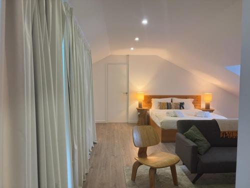 a bedroom with a bed and a chair and a couch at Autor Guesthouse in Vila do Conde