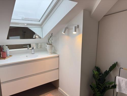 a bathroom with a sink and a skylight at Autor Guesthouse in Vila do Conde