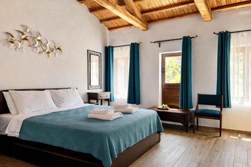 a bedroom with a bed with blue sheets and a chair at Armonia Cosy Loft Chora Samothraki View in Samothraki