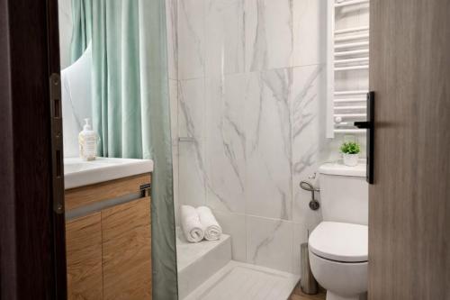 a white bathroom with a toilet and a sink at Armonia Cosy Loft Chora Samothraki View in Samothraki