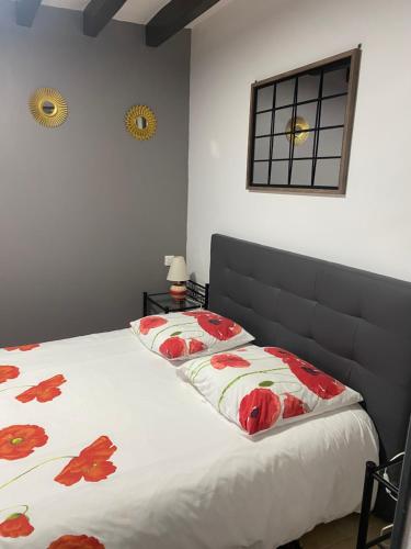 a bedroom with a bed with red flowers on it at Gite de Sainte Gemme in Sainte-Gemme