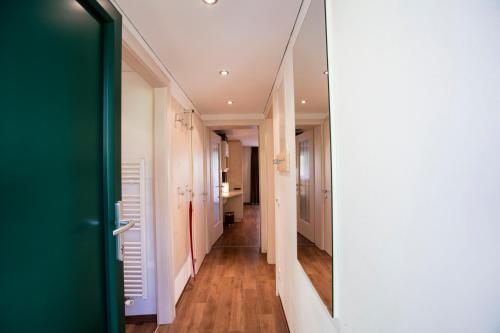 a hallway with white walls and a green door at Alpenhaus Montafon by Pferd auf Wolke in Gargellen