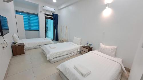a bedroom with two beds and a window at HT Airport Inn in Phù Xá Ðoài