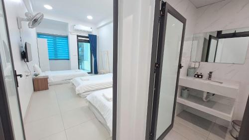 a bathroom with two beds and a sink and a mirror at HT Airport Inn in Phù Xá Ðoài