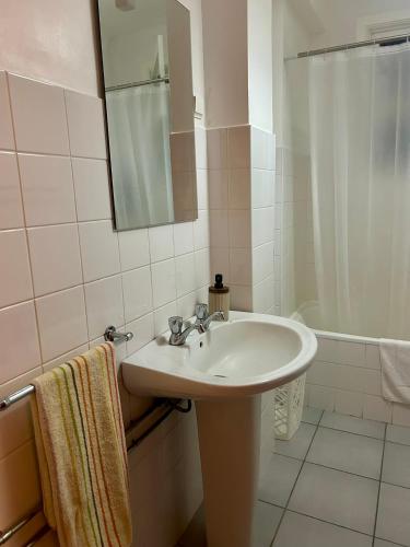 a white bathroom with a sink and a shower at City Center Apartment in Angra do Heroísmo