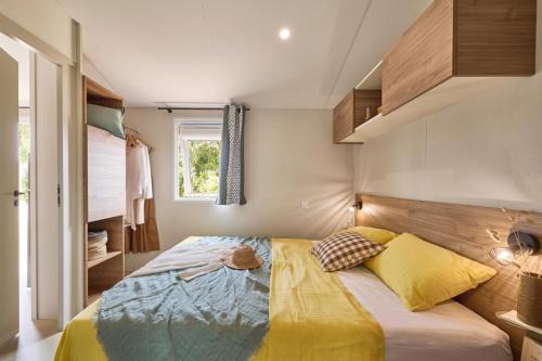 a bedroom with a bed with yellow and blue at Camping de Keranterec in La Forêt-Fouesnant