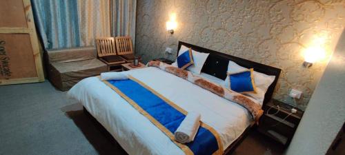 a bedroom with a large bed with blue and white pillows at Hill Side Cabin, Pangong in Spangmik